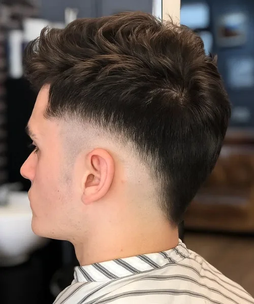 Drop fade Faux Hawk with curved taper and spiked crown for bold, sculpted contrast.