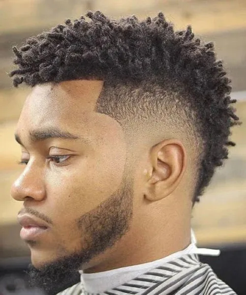 Faux Hawk for Black men with lifted coils and faded edges for bold texture and shape.