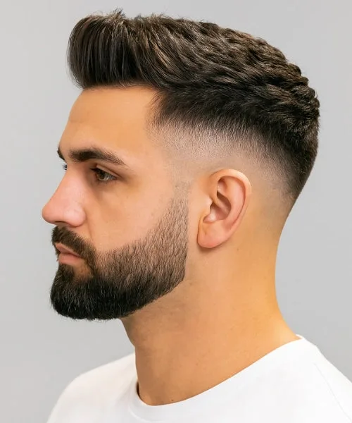 High fade Faux Hawk with lifted center and sharp edges for bold contrast and volume.