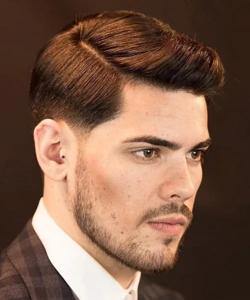 Medium length side part haircut with voluminous top, neat taper, and defined parting.