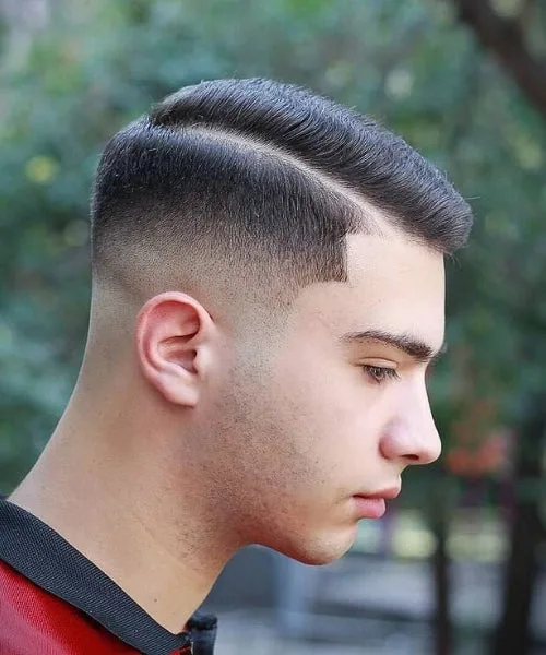 Side part mid fade haircut with structured top, clean taper, and defined parting.