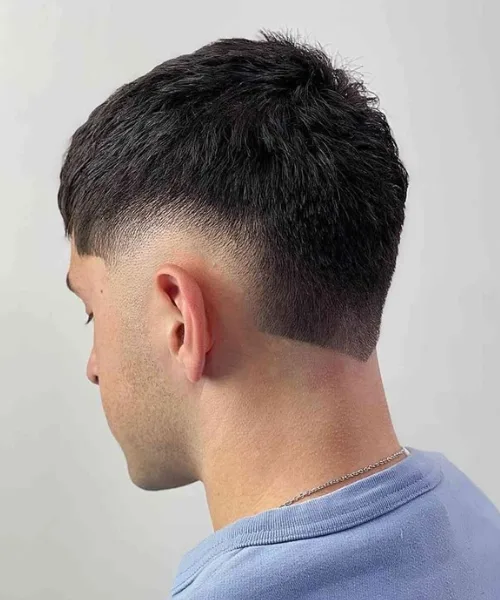 Burst skin fade haircut with curved fade around the ear and styled top for modern edge