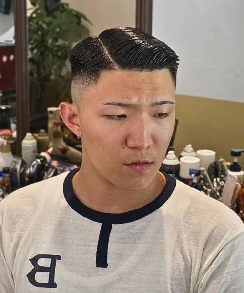 Asian comb over haircut with clean faded sides and sleek parted top for sharp modern definition