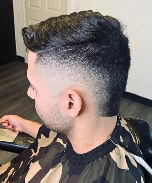 Comb over mohawk haircut with edgy faded sides and voluminous brushed top for bold trendy look