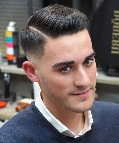 Comb over with low fade haircut featuring smooth transitions and polished top for clean style
