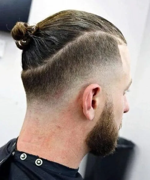 Drop Fade with tied man bun and sharp faded sides for modern trendy style