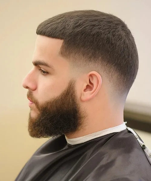 Drop Fade haircut with full beard and sharp faded sides for bold masculine look