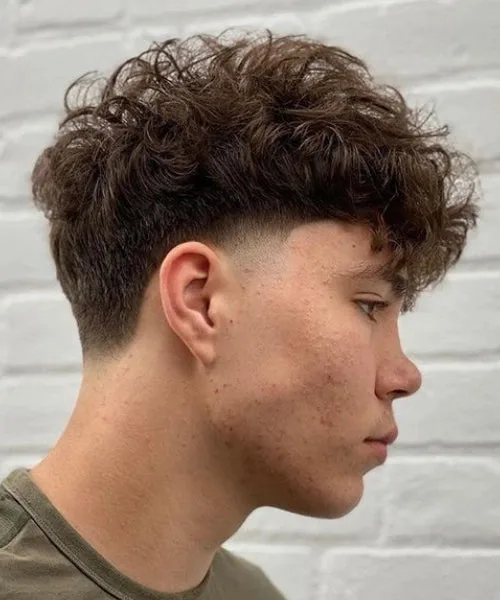 Low temp fade haircut with soft taper and textured top for neat, balanced men’s look.