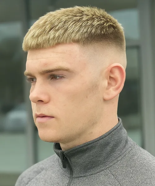 Skin fade blonde haircut with light blonde tones on top and sharp faded sides