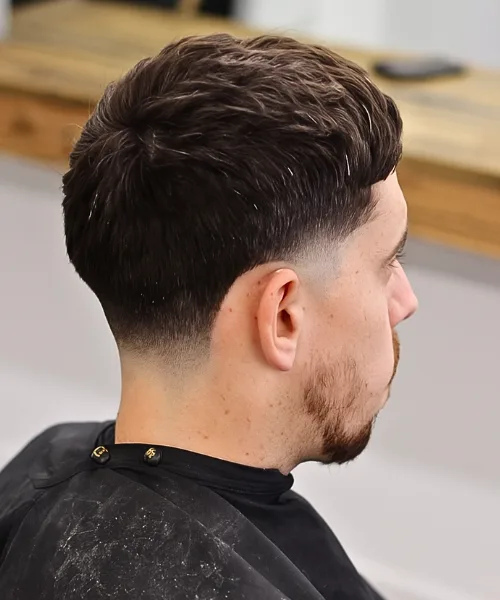 Low taper skin fade haircut with smooth fade and fuller top for a versatile modern look