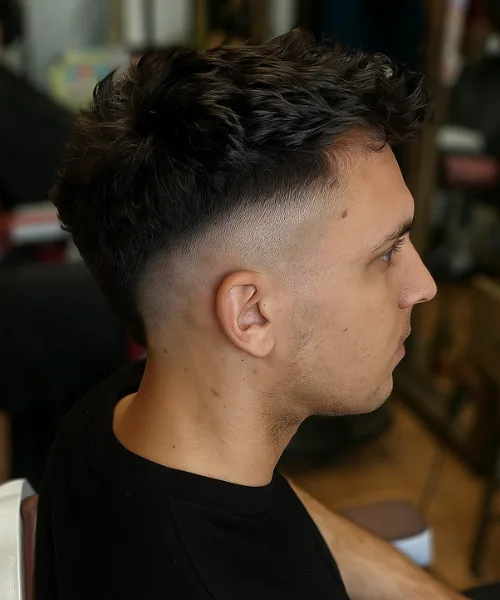 Skin fade mohawk haircut with shaved sides and spiked textured top for edgy style