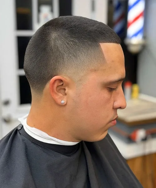 Temple fade buzz cut with clean faded temples and short even top for minimal bold style.