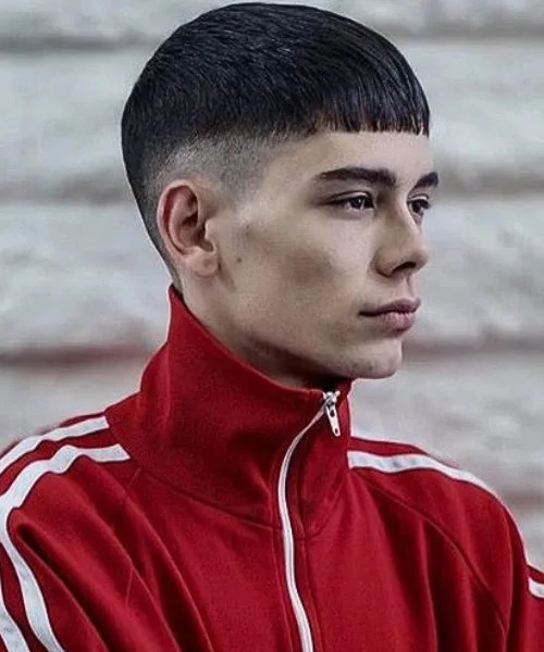 Caesar fade haircut with clean faded sides, straight fringe, and voluminous textured top