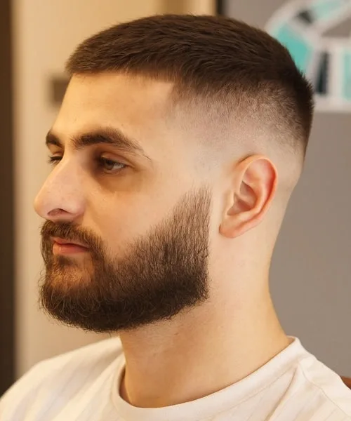 Caesar haircut with short fringe, faded sides, and full groomed beard for a bold, balanced look