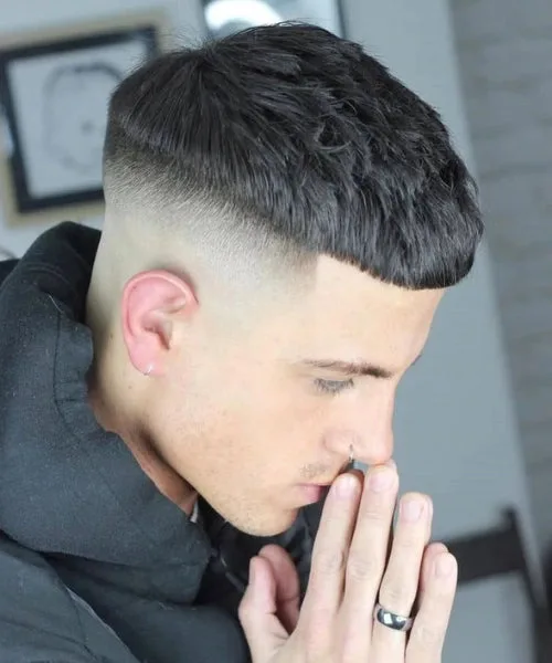 High fade Caesar cut with defined fringe, sharp contrast, and bold textured top