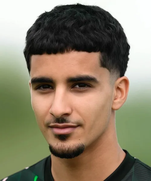 Low taper Caesar cut with short fringe, blended taper fade, and layered top styling