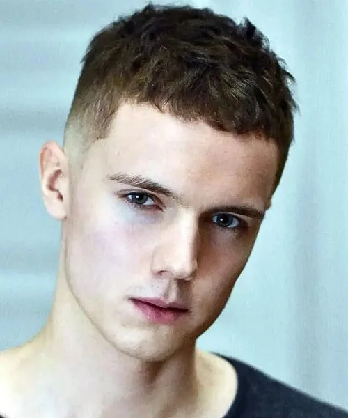 Messy Caesar cut with layered fringe, faded sides, and tousled textured top for a casual look