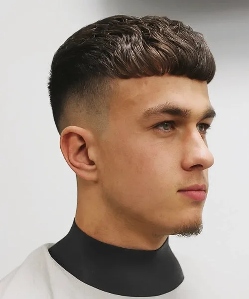 Wavy Caesar cut with short fringe, low faded sides, and naturally textured waves on top