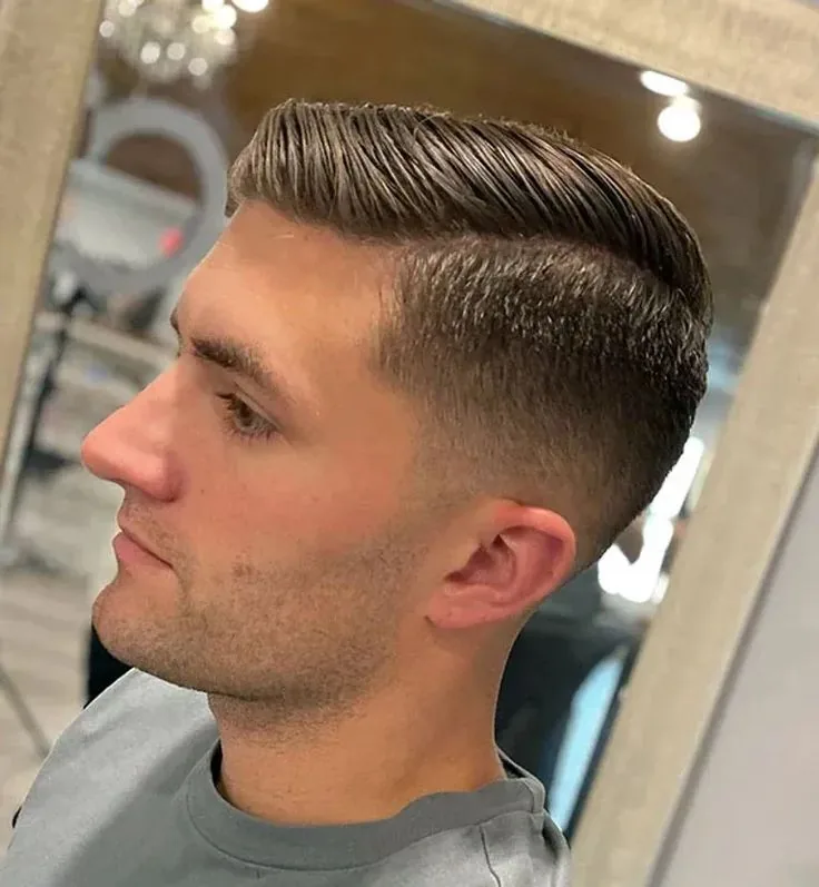 Comb over low taper fade on straight hair with a side part and clean low taper