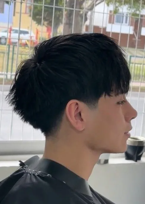 Messy textured top low taper fade on straight hair with a relaxed finish