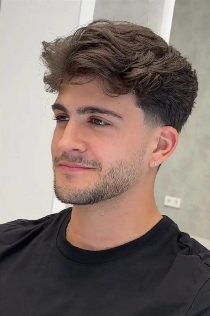 Quiff low taper fade on straight hair with volume swept up at the front
