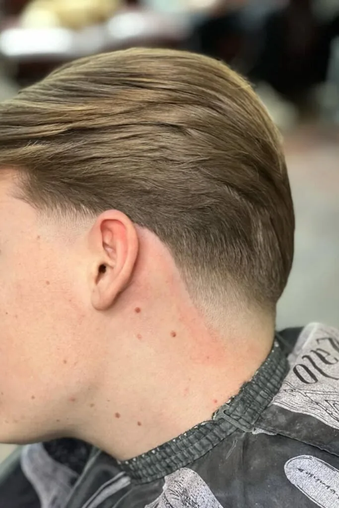 Slick back low taper fade on straight hair combed straight back